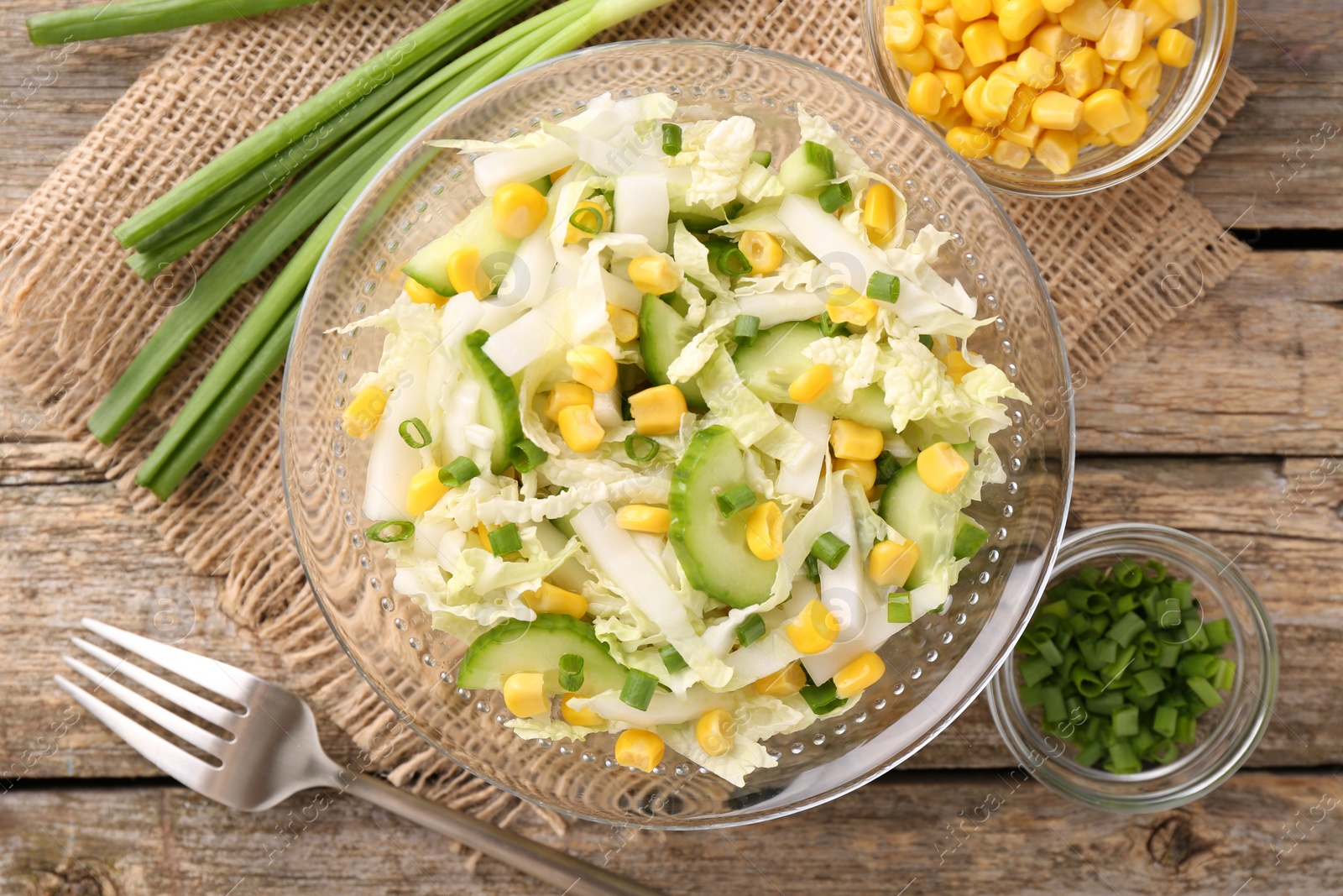 Photo of Tasty salad with Chinese cabbage served on wooden table, flat lay