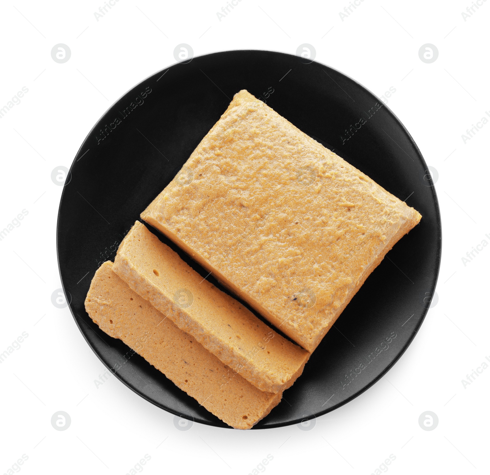 Photo of Black plate with quince paste isolated on white, top view