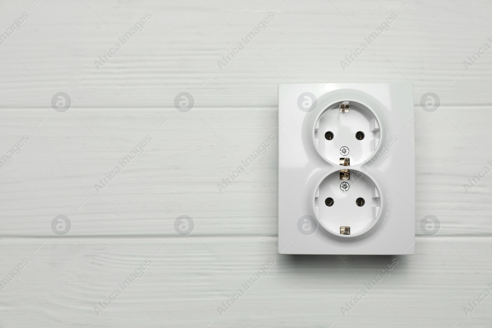 Photo of Modern plastic power socket on white wooden table, top view. Space for text