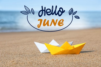 Image of Hello June. Color paper boats on sandy beach near sea