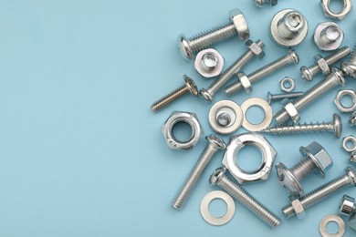 Many different fasteners on light blue background, flat lay. Space for text