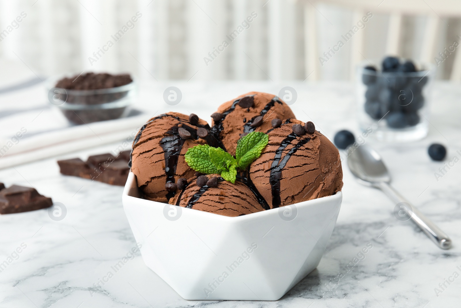 Photo of Bowl of chocolate ice cream and mint on marble table