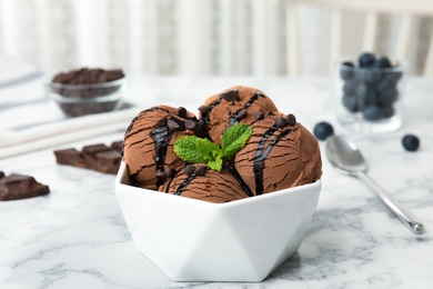 Bowl of chocolate ice cream and mint on marble table