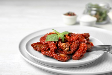 Photo of Plate with sun dried tomatoes on light table