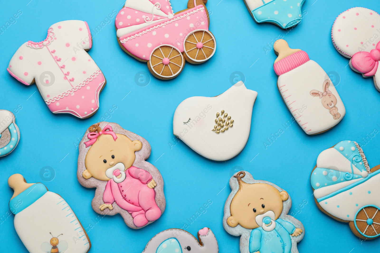 Photo of Cute tasty cookies of different shapes on light blue background, flat lay. Baby shower party