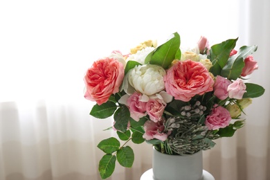 Photo of Vase with beautiful flower bouquet in front of window