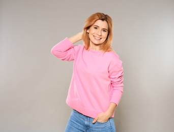 Portrait of beautiful woman posing on grey background