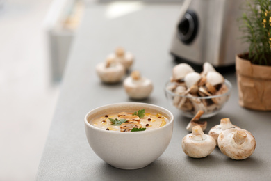 Delicious cream soup with mushrooms on grey table