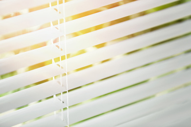 Window with blinds on sunny day, closeup