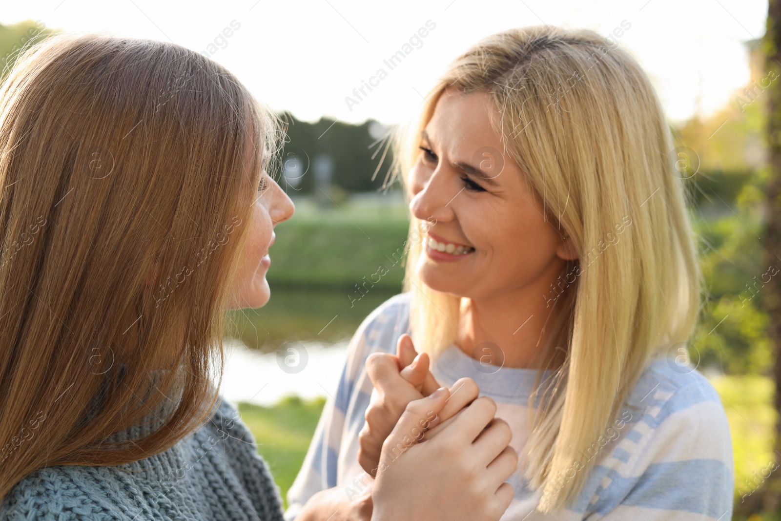 Photo of Happy mother with her daughter spending time together in park on sunny day