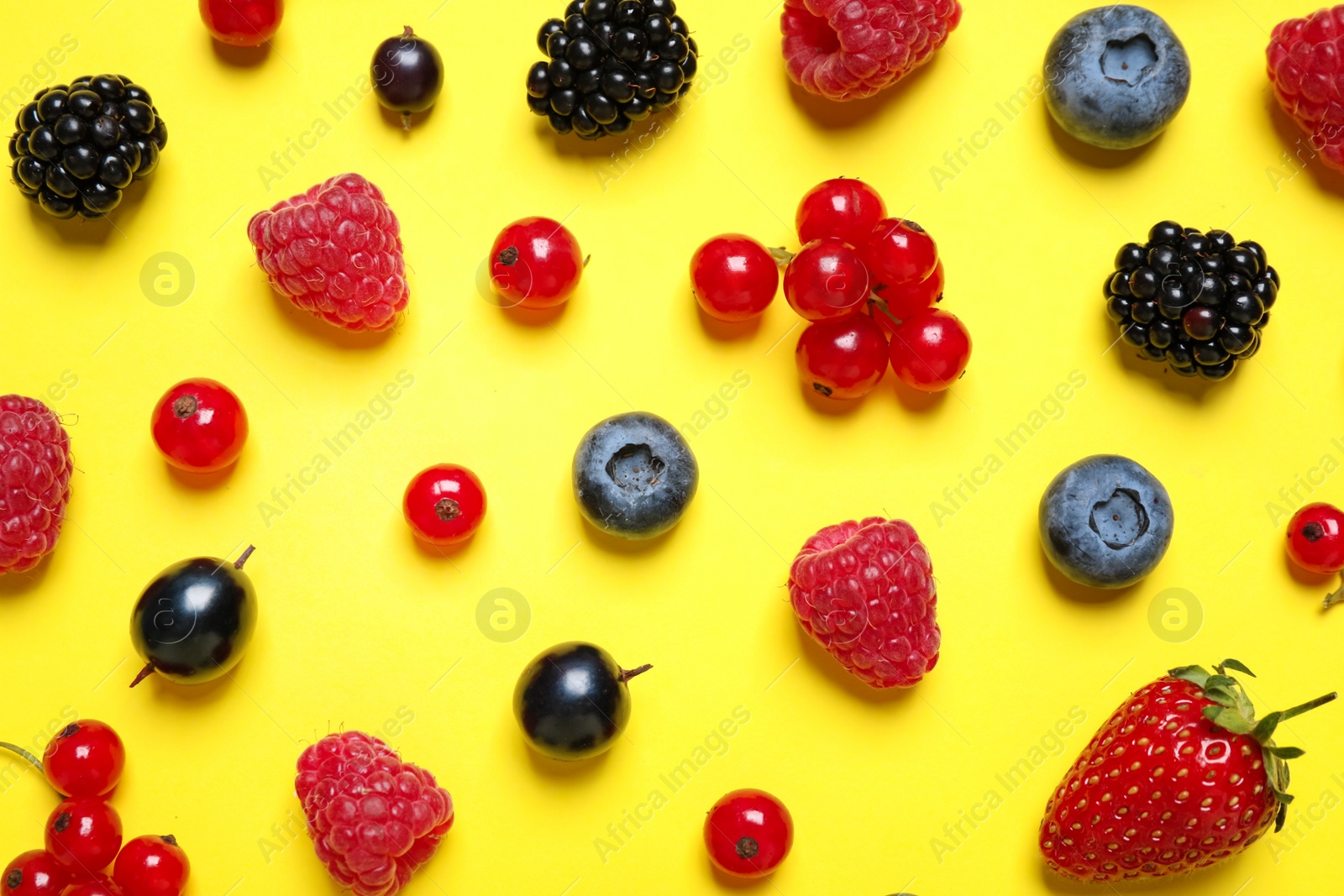 Photo of Mix of fresh berries on yellow background, flat lay