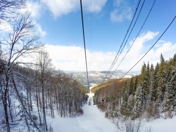 Photo of Modern chairlift on snowy mountain at ski resort, wide angle lens effect