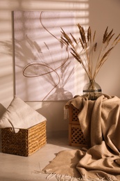 Photo of Vase with decorative dried plants and painting in stylish room interior