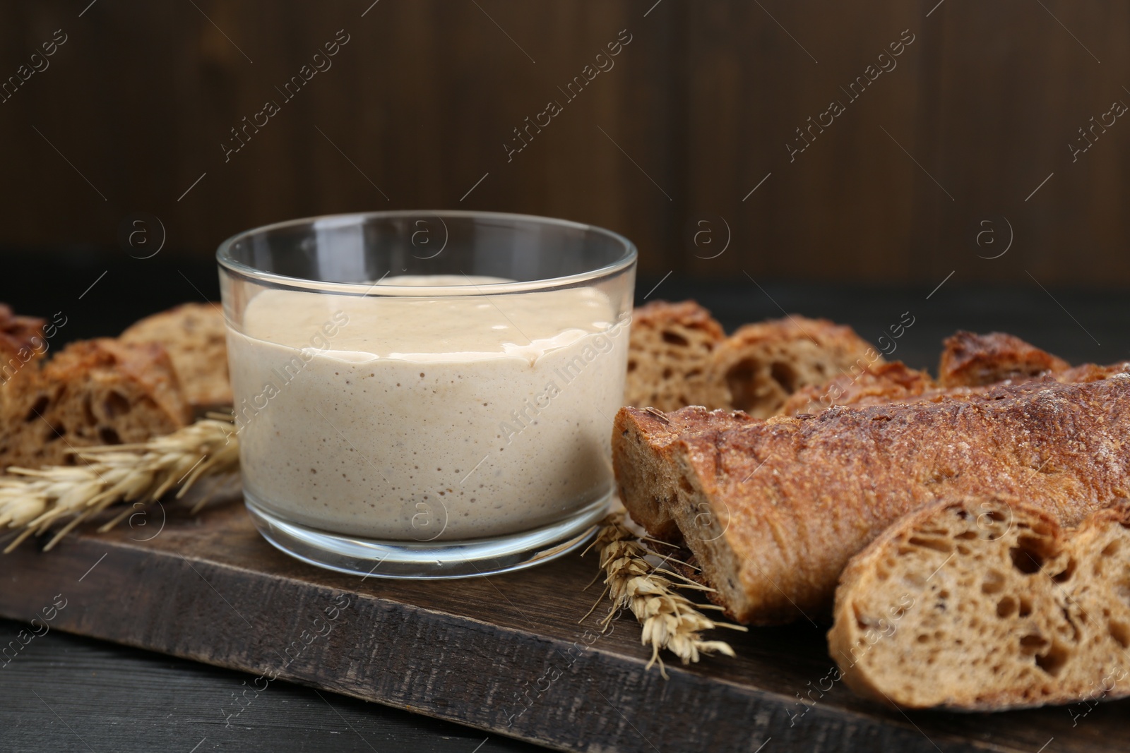 Photo of Freshly baked bread, sourdough and spikes on wooden table, closeup