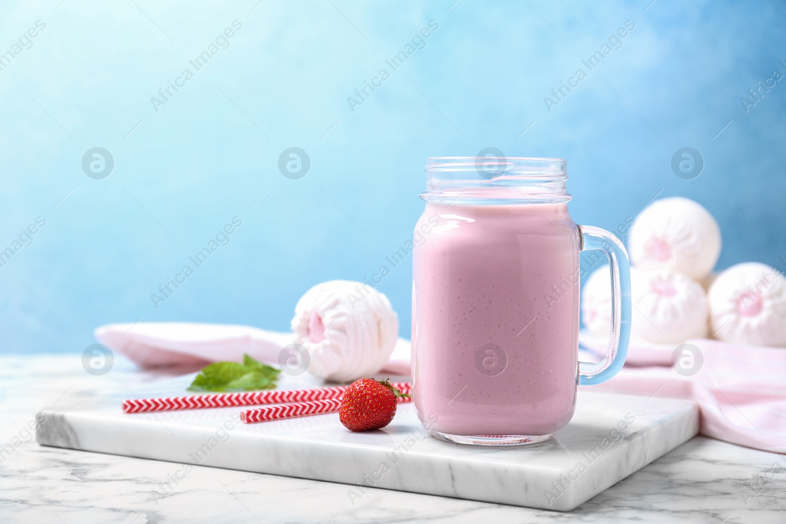 Photo of Mason jar with delicious milk shake on table