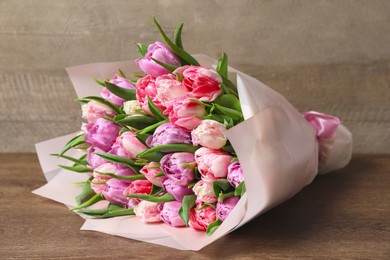 Photo of Bouquet of beautiful tulips on wooden table