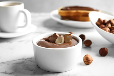 Photo of Sweet chocolate mousse with hazelnuts served on marble table