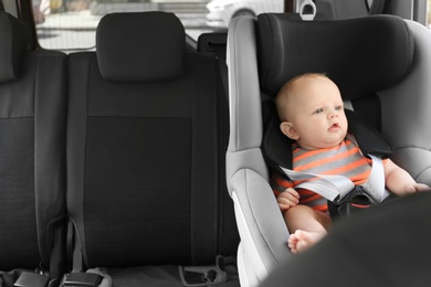 Photo of Little baby in child safety seat inside of car