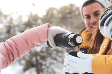 Happy family with thermos outdoors on winter day, closeup. Christmas vacation