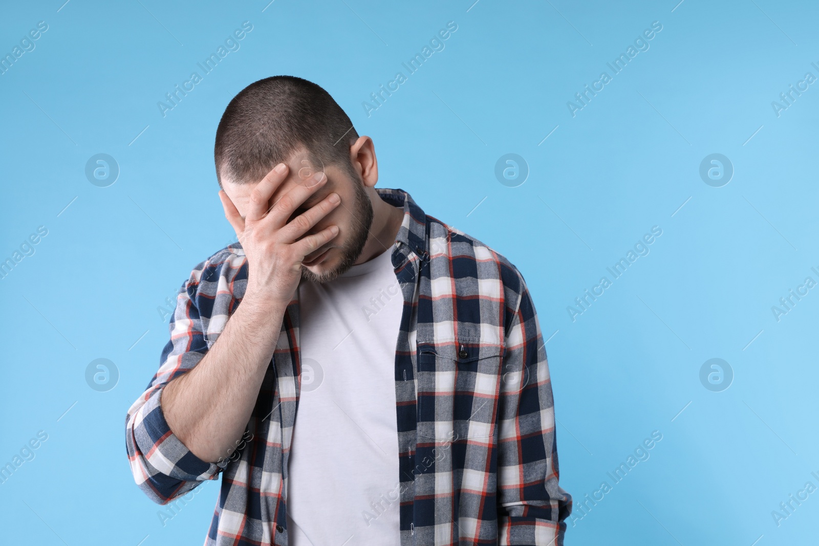 Photo of Upset man in shirt on light blue background