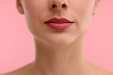 Photo of Woman with beautiful lips on pink background, closeup