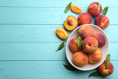 Photo of Fresh sweet peaches on turquoise wooden table, flat lay. Space for text