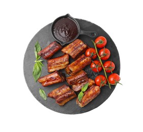 Photo of Tasty roasted pork ribs, basil, sauce and tomatoes isolated on white, top view