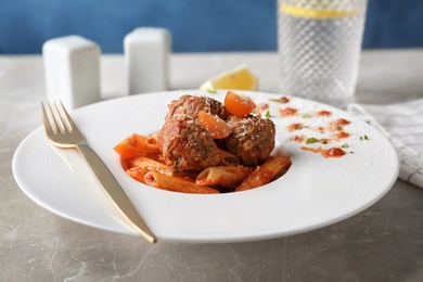 Photo of Delicious pasta with meatballs and tomato sauce on plate, closeup