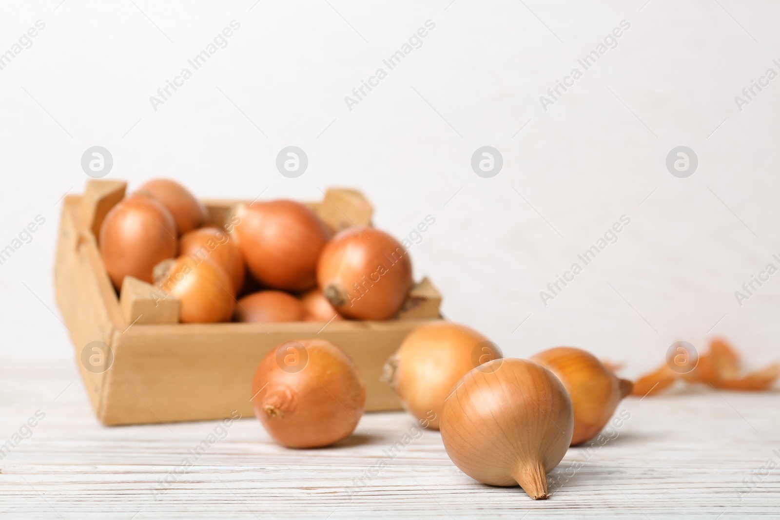 Photo of Fresh ripe onions on wooden table