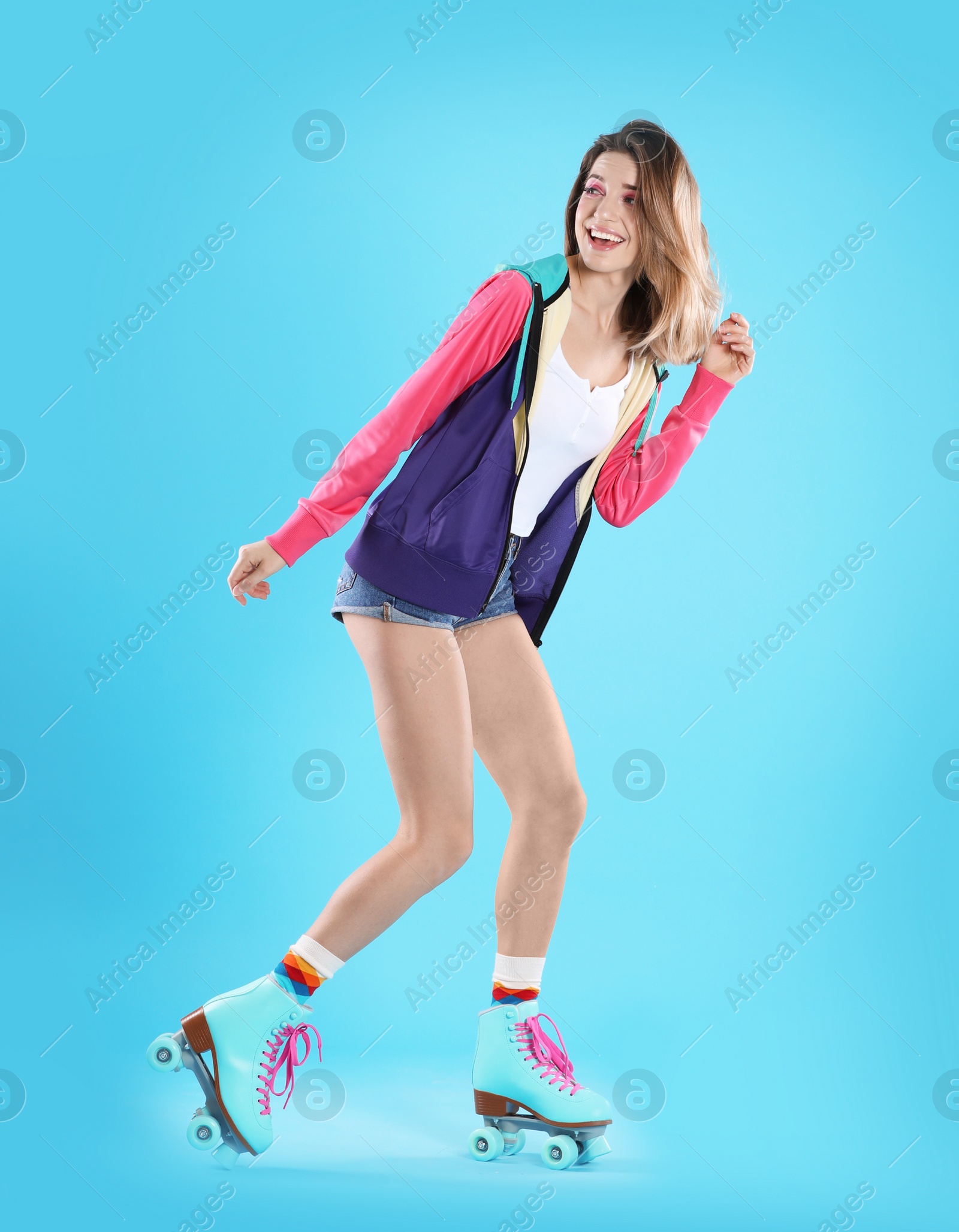 Photo of Young woman with retro roller skates on color background