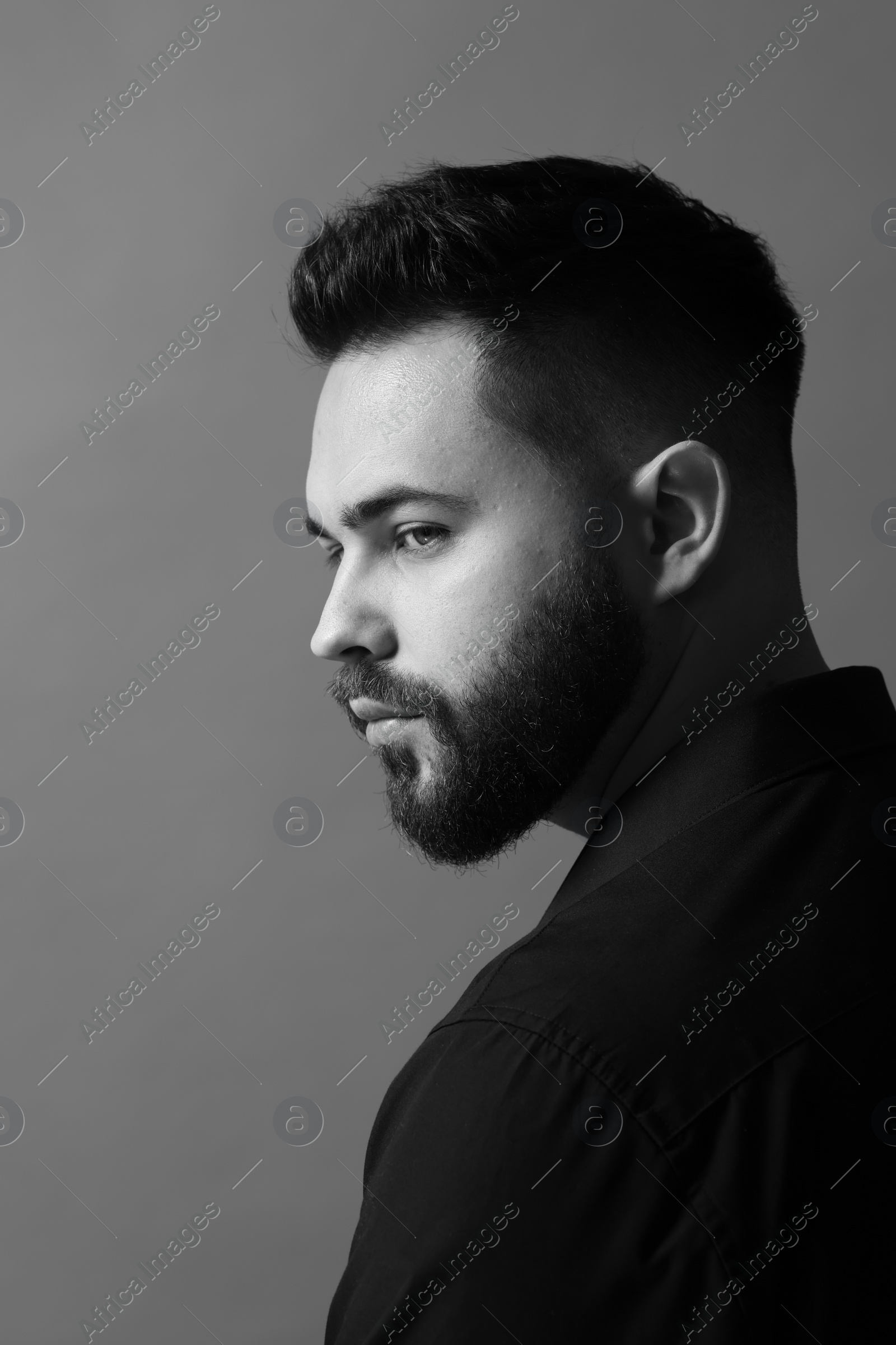 Photo of Portrait of handsome bearded man on grey background. Black and white effect