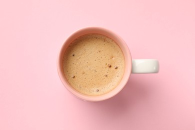 Photo of Aromatic coffee in cup on pink background, top view