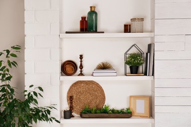 Photo of Wall shelves with beautiful decor elements indoors. Interior design