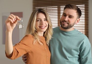 Happy young couple with key in new house