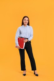 Photo of Happy woman with folder on orange background