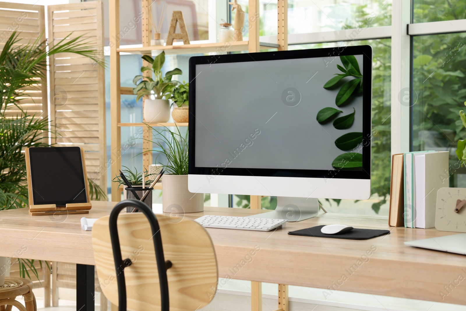 Photo of Comfortable workplace with computer in light room. Interior design