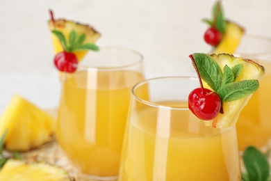 Photo of Glasses with delicious pineapple juice on table, closeup