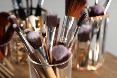Photo of Set of professional brushes on wooden table, closeup