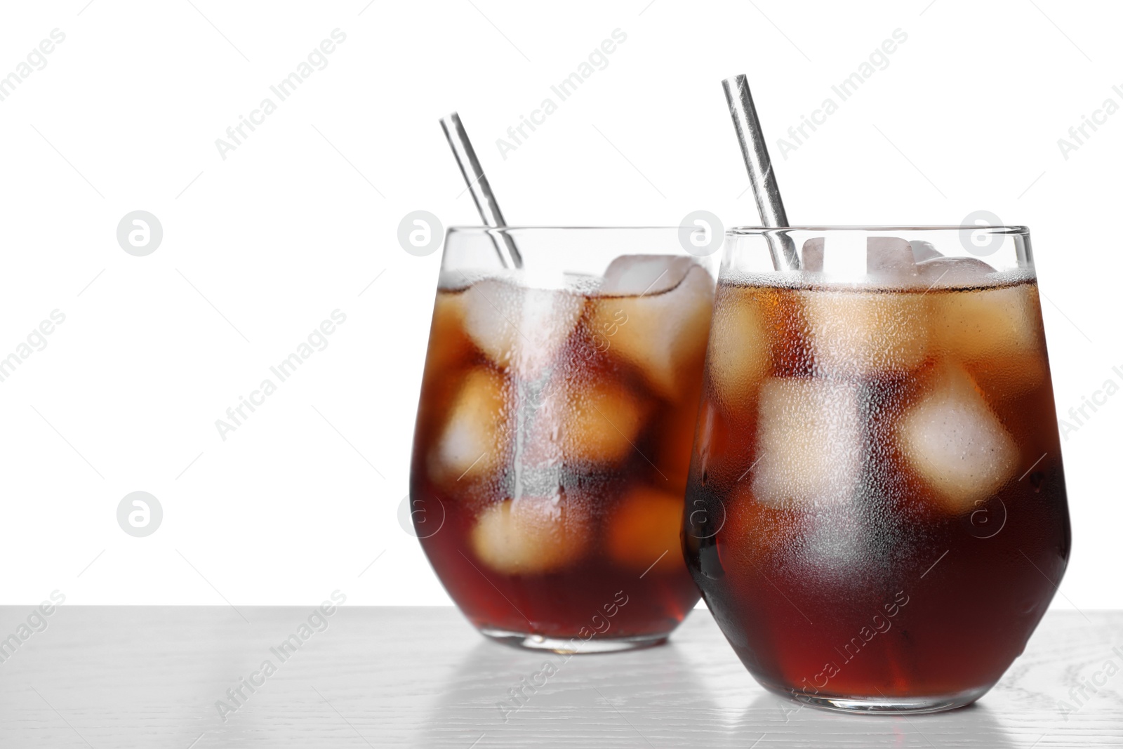 Photo of Tasty cola with ice cubes on table against white background