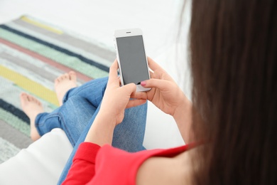 Young woman using mobile phone at home