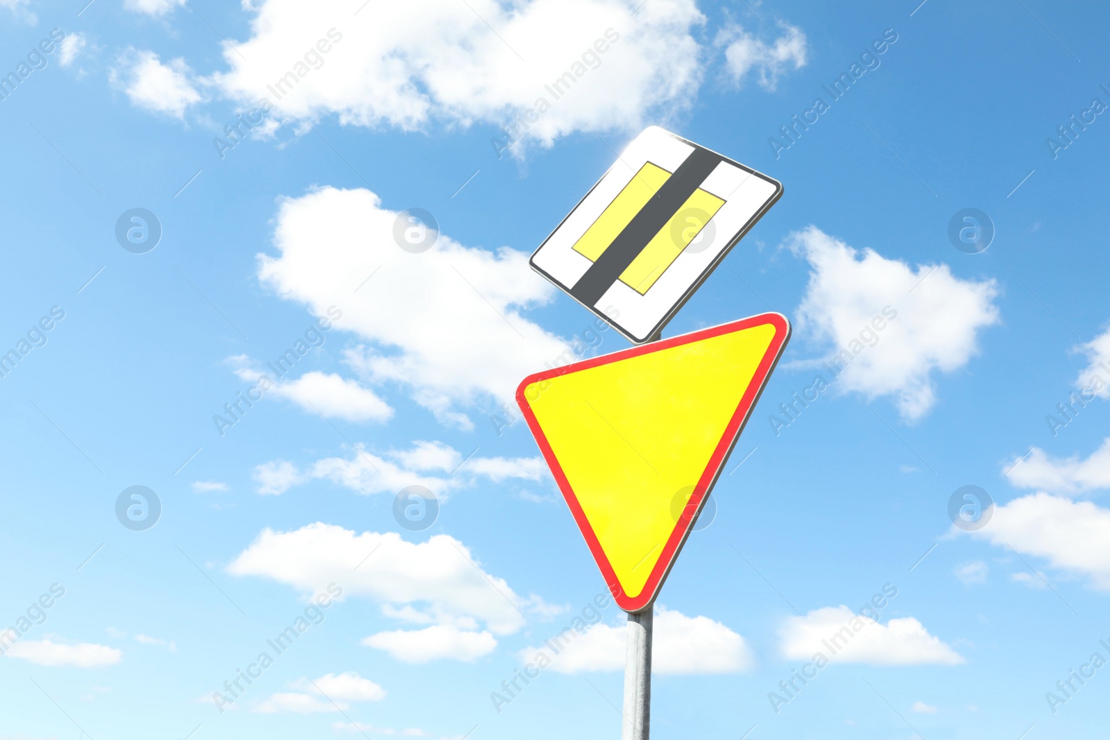 Photo of Traffic signs End Of Priority Road and Yield against blue sky, space for text