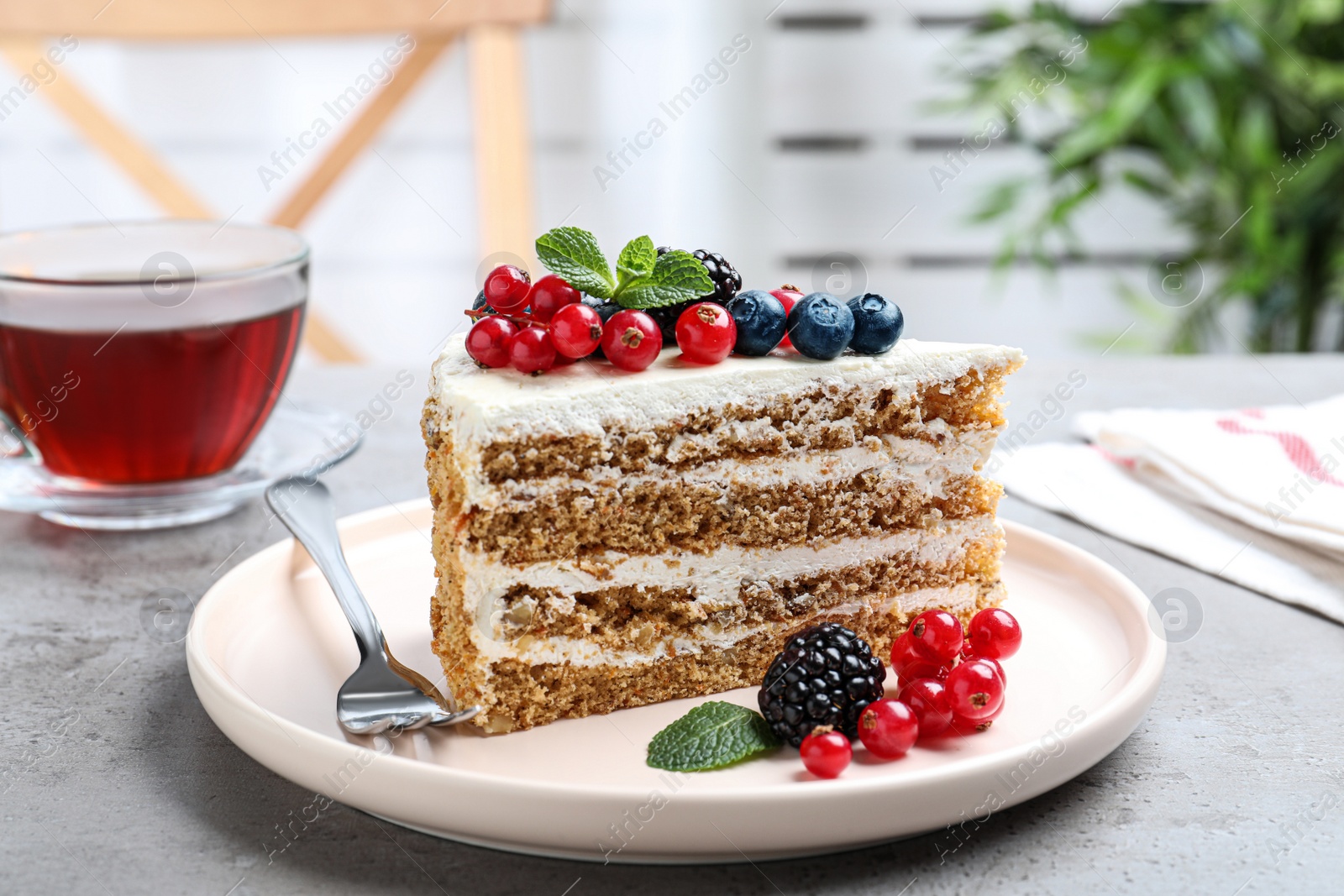 Photo of Tasty cake with berries on grey table indoors