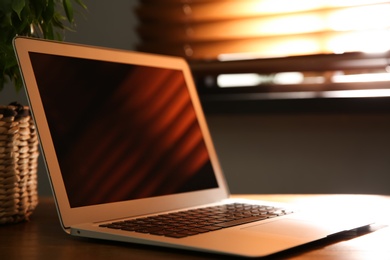 Photo of Modern laptop on wooden table indoors. Space for design