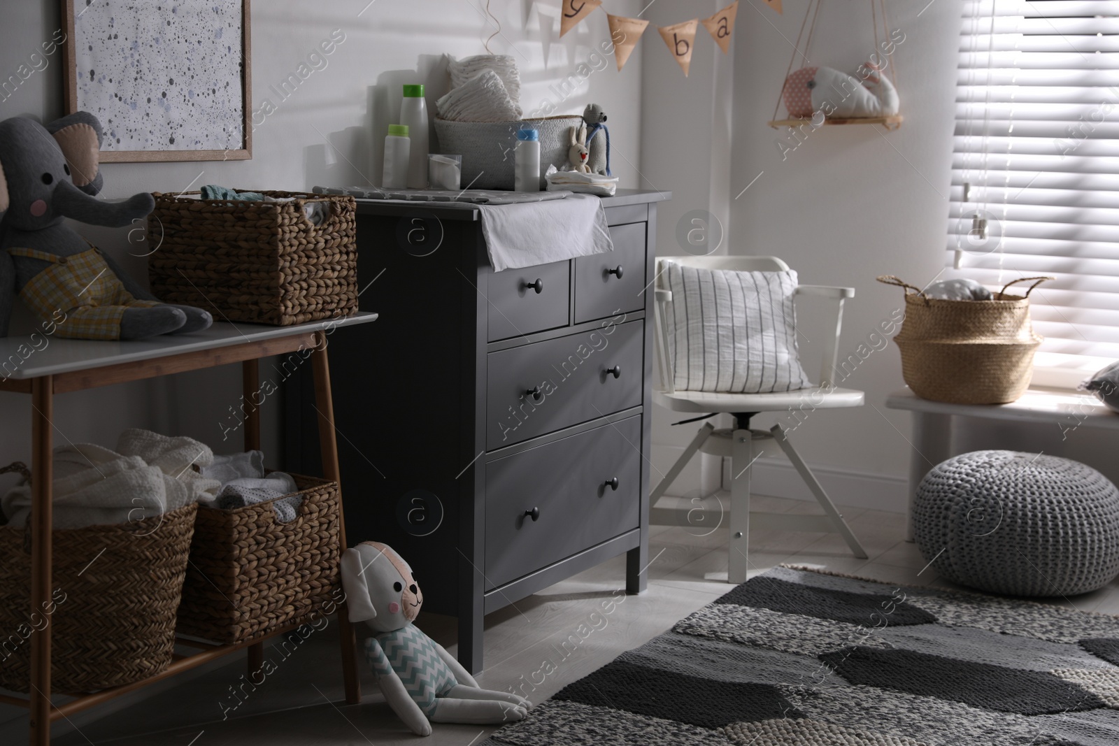 Photo of Chest of drawers with changing place in baby room. Interior design