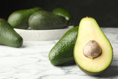 Photo of Delicious ripe avocados on white marble table