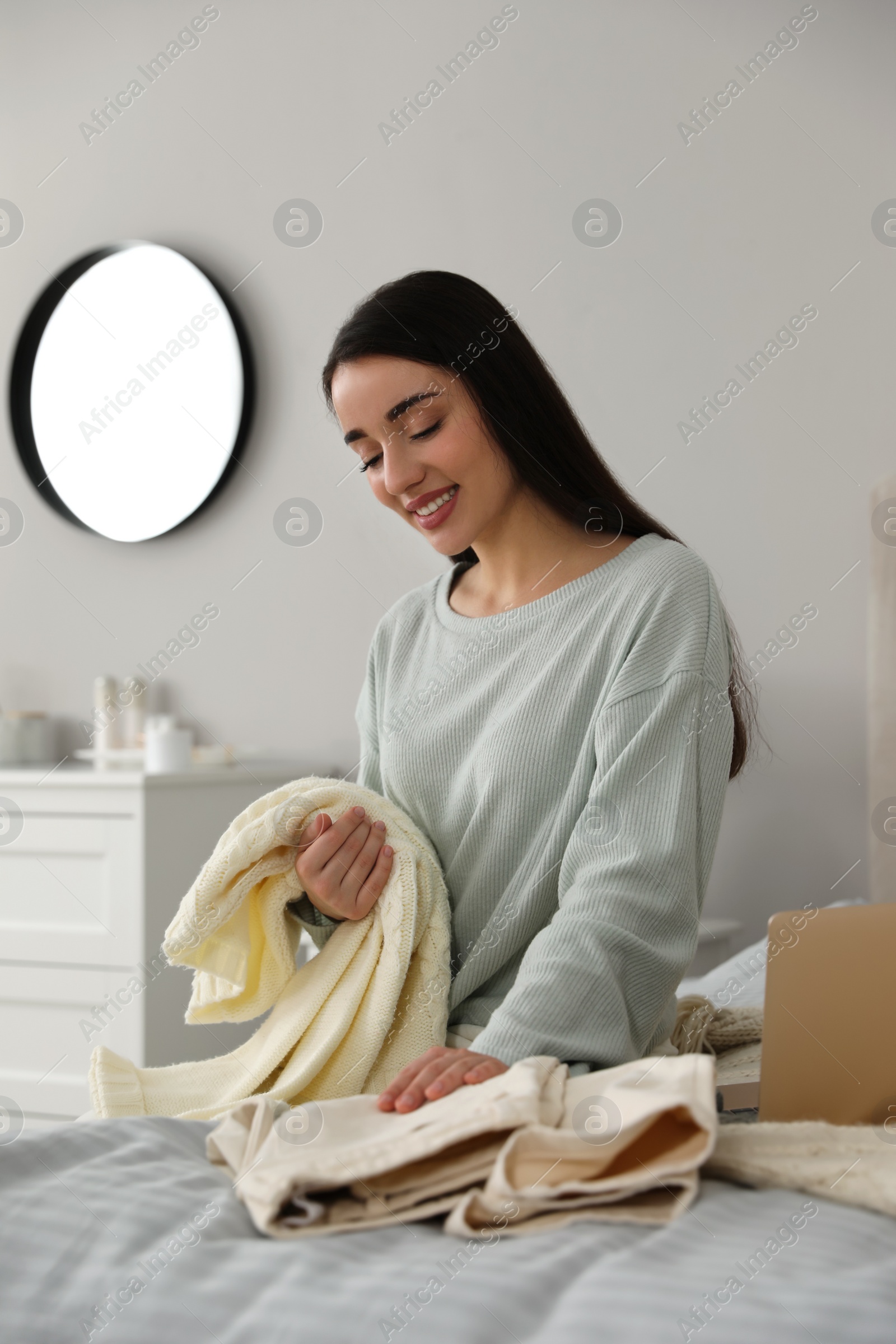 Photo of Young woman choosing clothes for work day at home. Morning routine