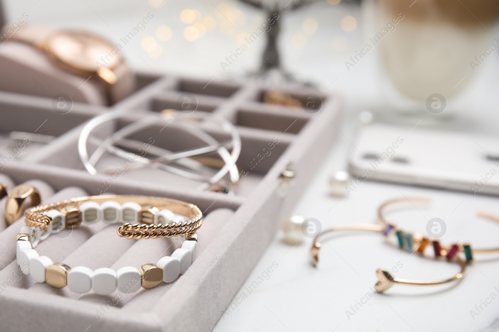 Photo of Elegant jewelry box with beautiful bijouterie on white table, closeup