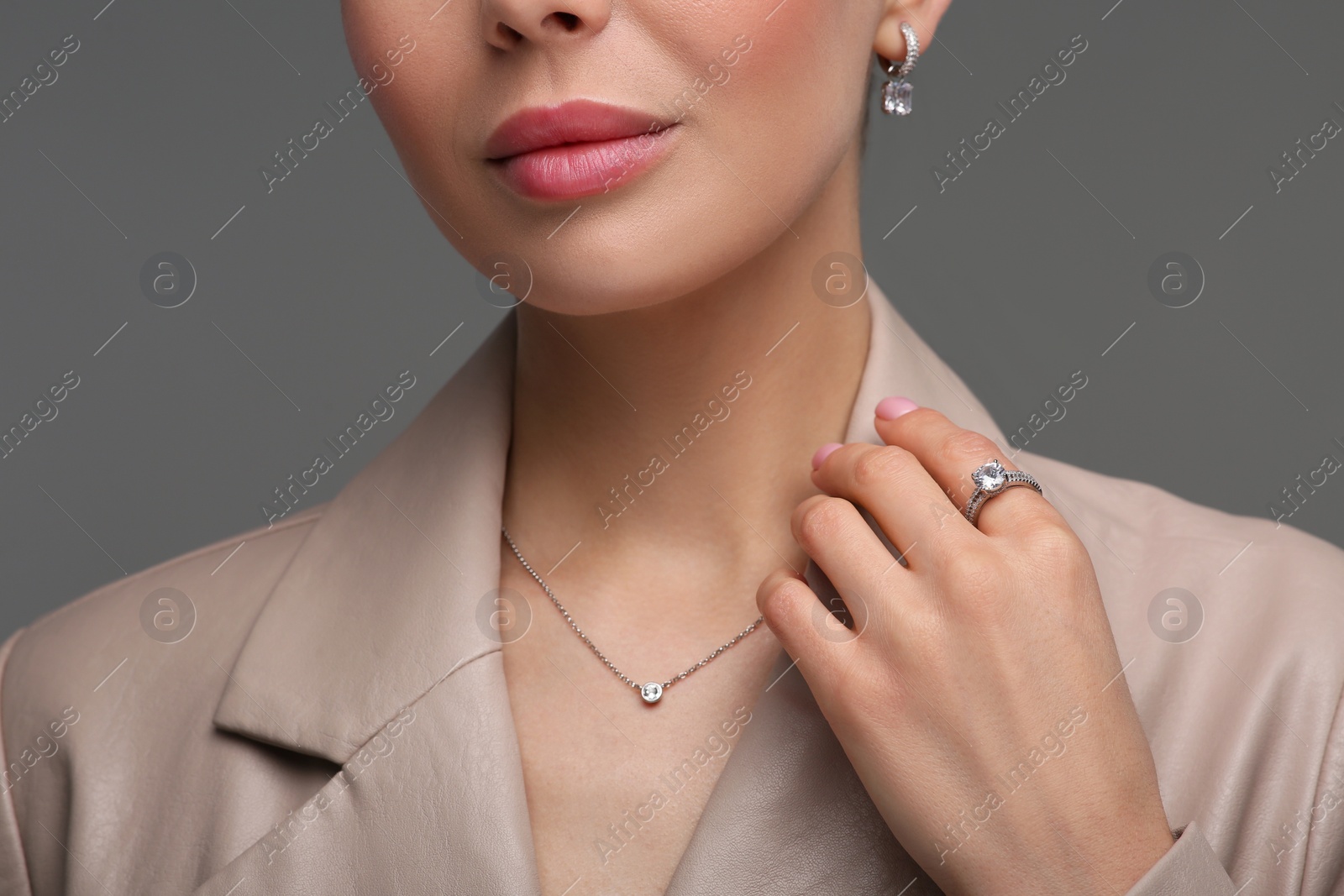 Photo of Young woman with elegant jewelry on dark grey background, closeup