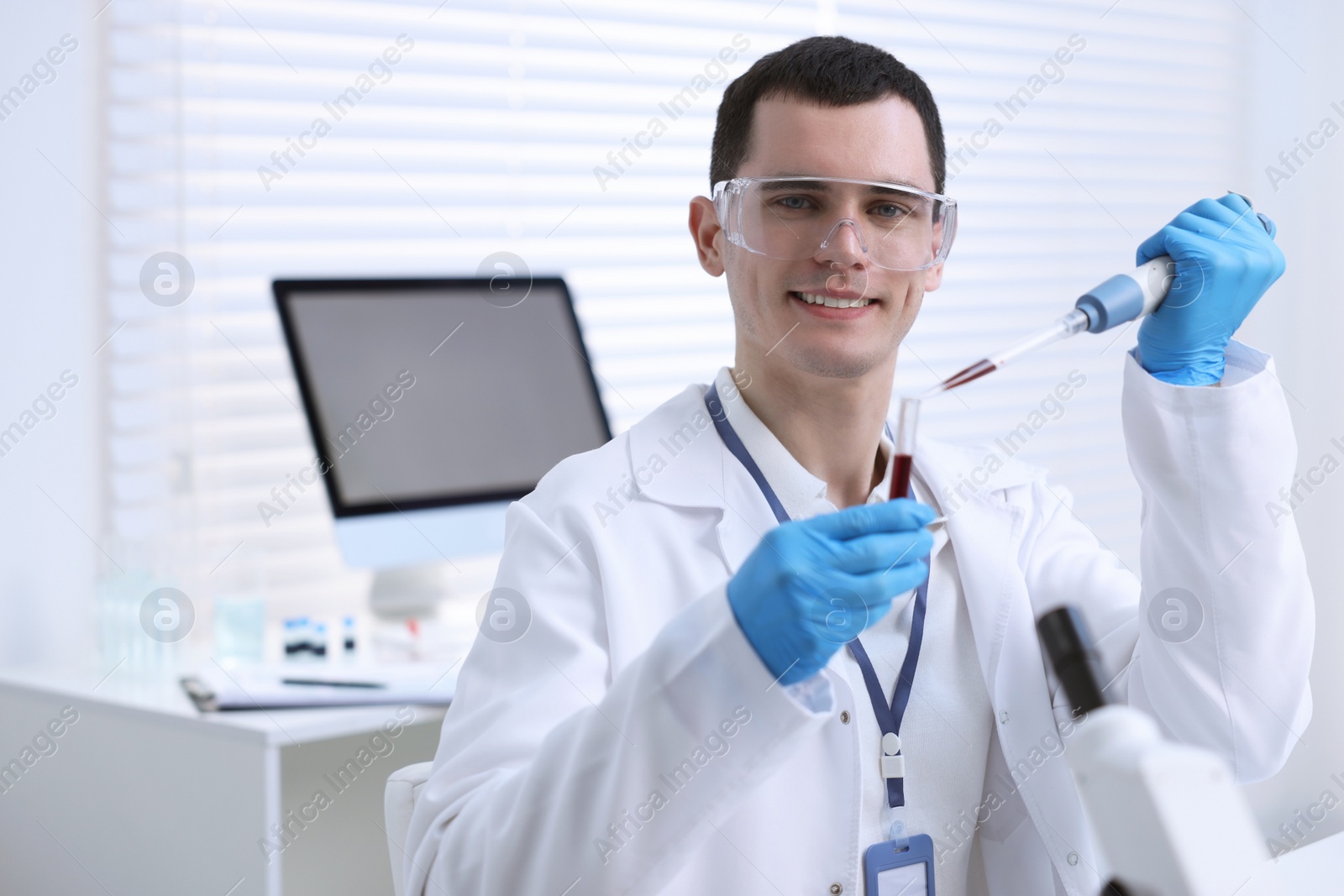 Photo of Scientist dripping sample into test tube in laboratory