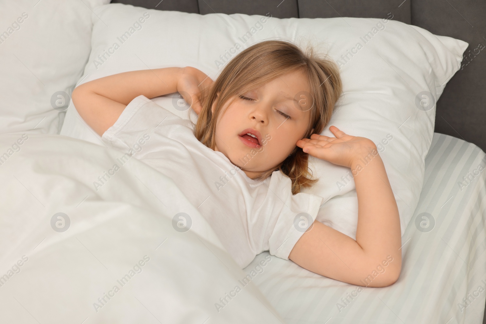 Photo of Little girl snoring while sleeping in bed